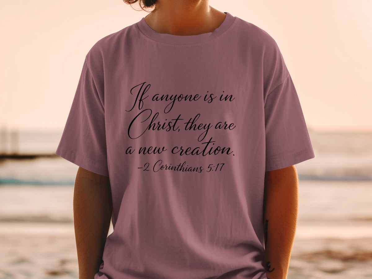 Mauve t-shirt with text "If anyone is in Christ, they are a new creation. -2 Corinthians 5:17"