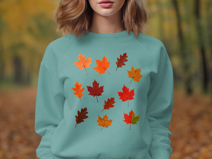 Teal sweatshirt with scattered multi-colored autumn leaf print.