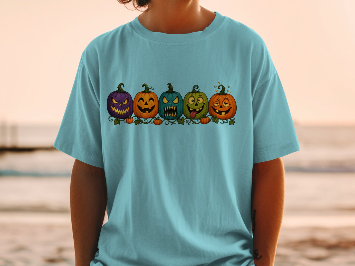 Light blue t-shirt with five cartoon Halloween pumpkins in a row.