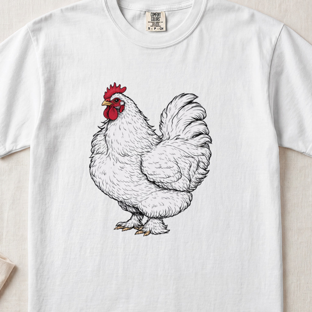 A white crewneck t-shirt featuring an illustration of a fluffy white rooster with a red comb.