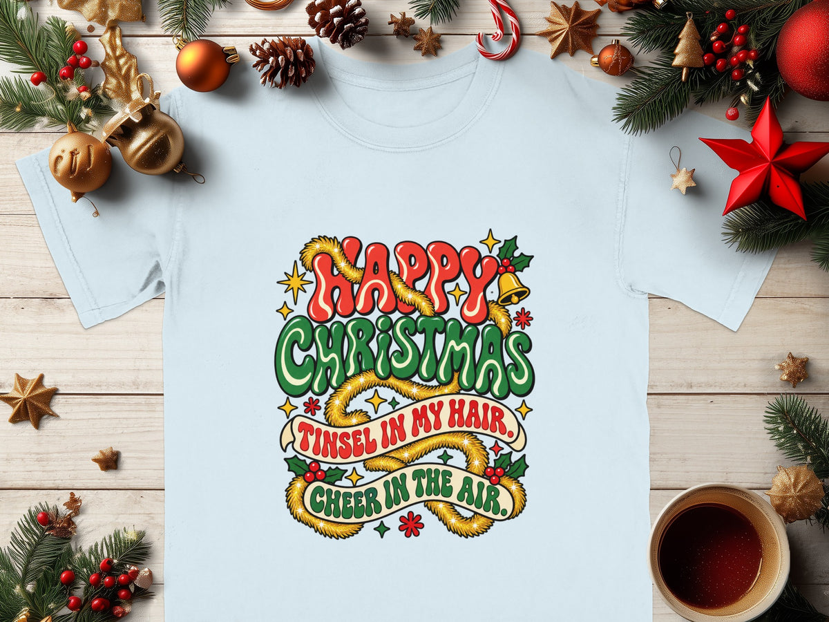 Light blue t-shirt with "Happy Christmas, Tinsel in My Hair, Cheer in the Air" holiday graphic.