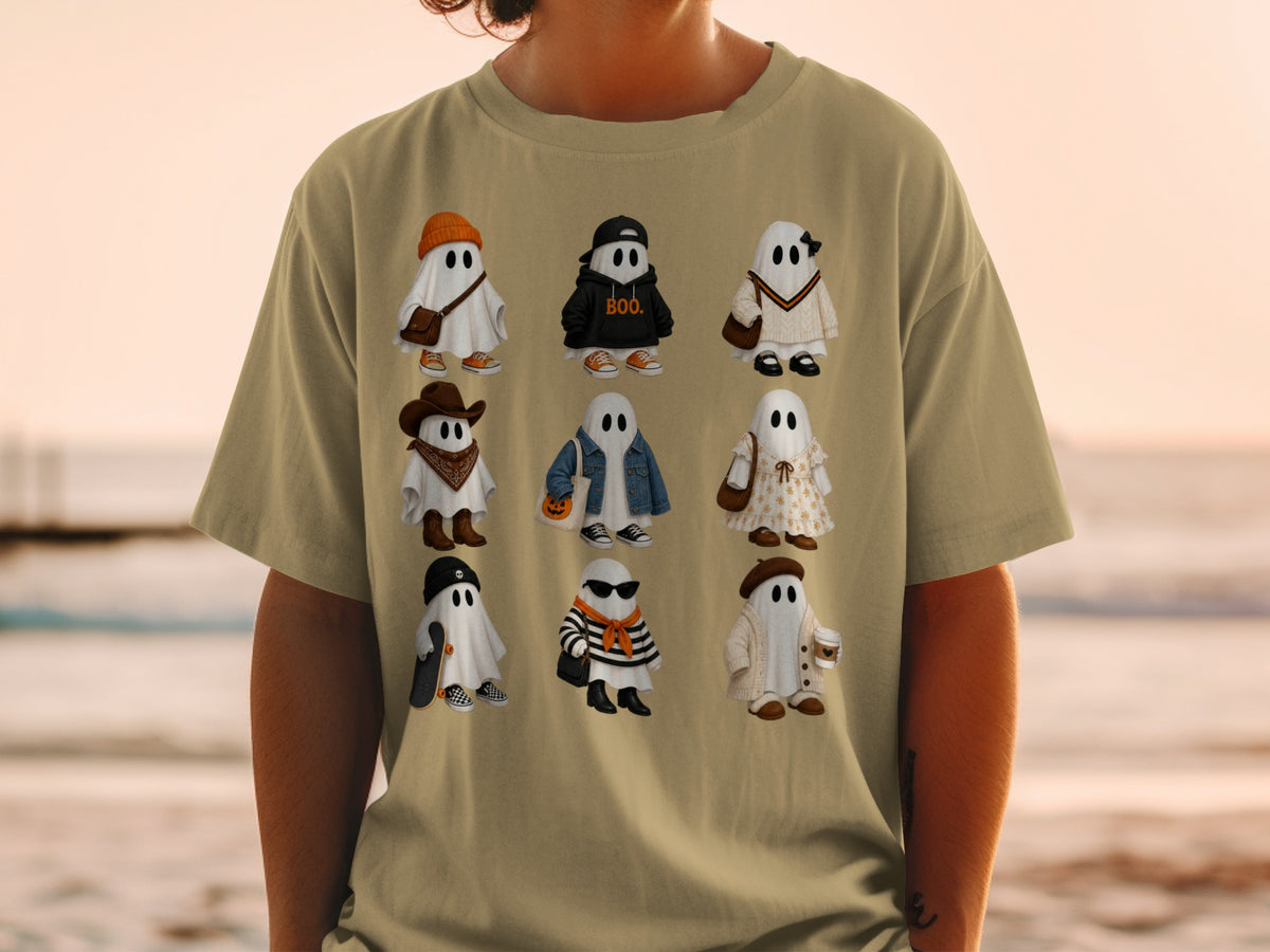 Nine cartoon ghosts in various outfits on a tan t-shirt.