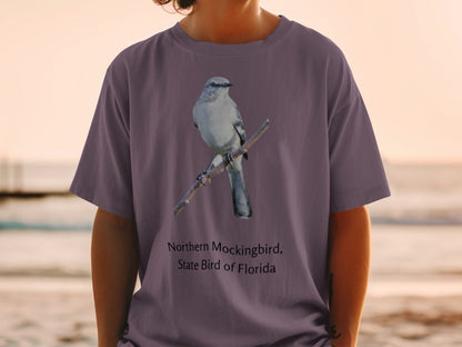 Northern Mockingbird, State Bird of Florida printed on a purple t-shirt.