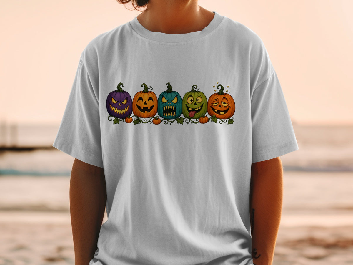 Five cartoon Halloween pumpkins with different expressions on a t-shirt.