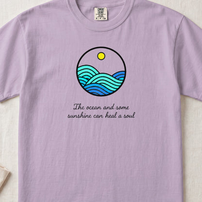 Light purple t-shirt featuring a circular ocean graphic with a sun and the text "The ocean and some sunshine can heal a soul."