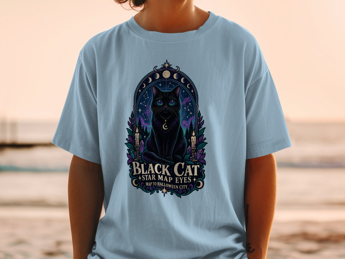 Black cat with star map eyes design on a light blue t-shirt.