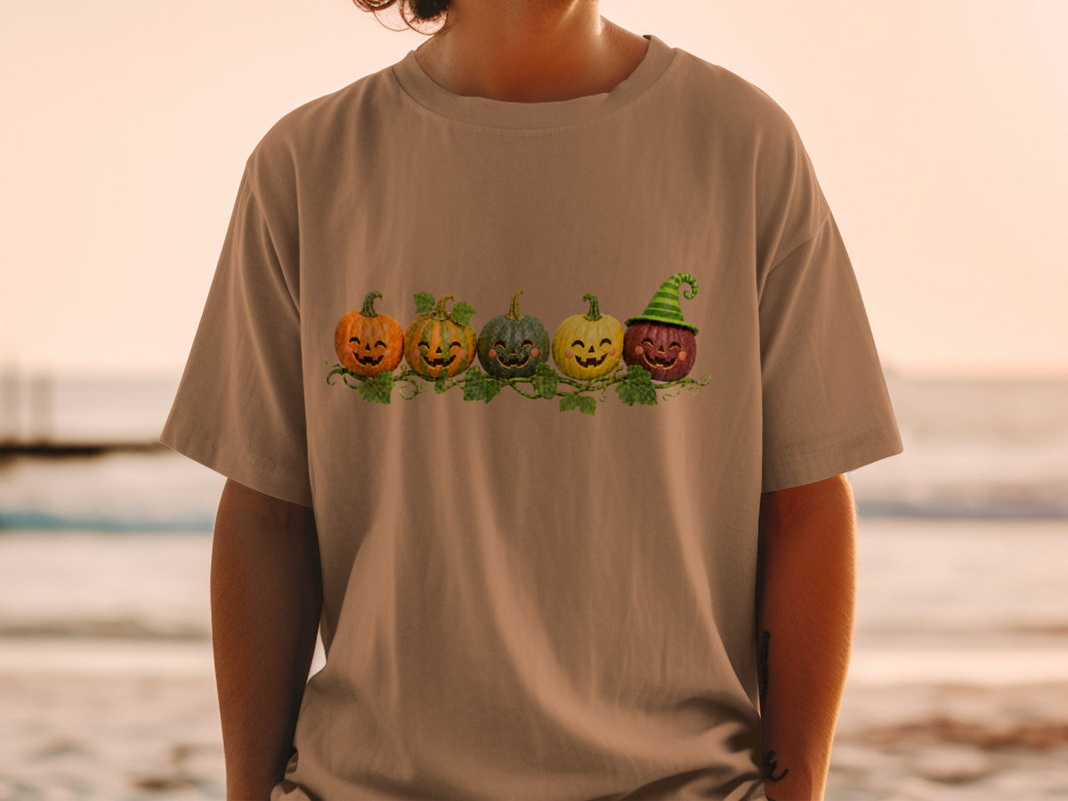 T-shirt with a row of five smiling cartoon pumpkins and green vines.