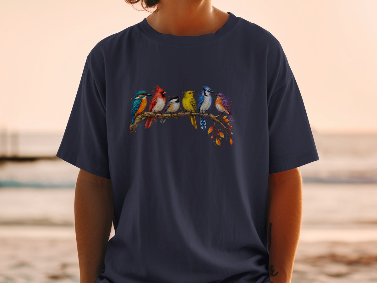 Six colorful birds perch on a branch with autumn leaves on a dark t-shirt.
