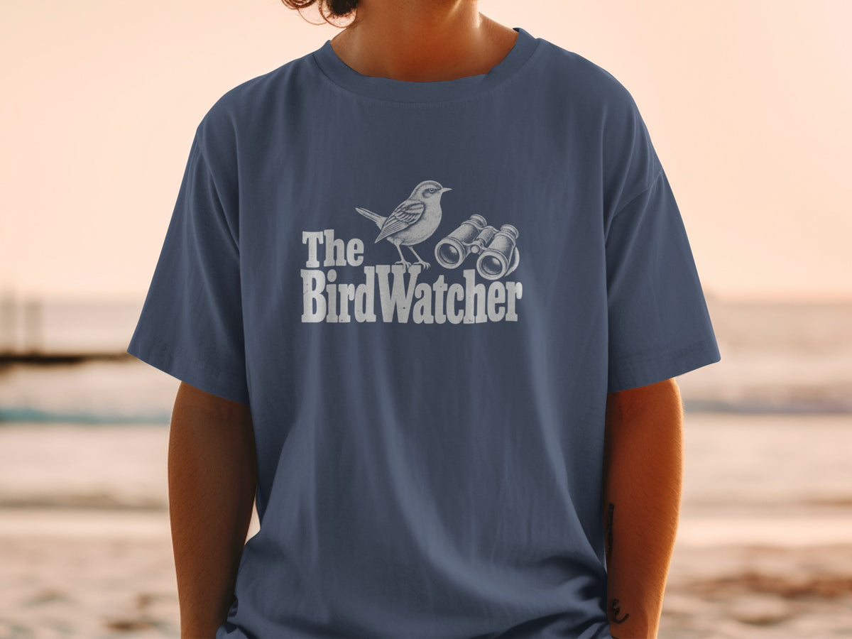 Blue t-shirt with "The BirdWatcher" text, a bird, and binoculars graphic.