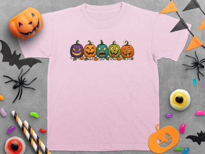 Pink t-shirt with a cartoon of five different colored pumpkins with faces.
