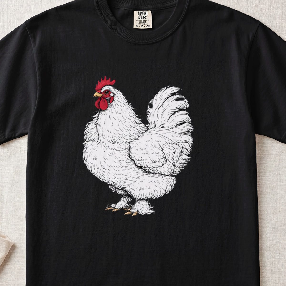 A black t-shirt featuring a detailed illustration of a white rooster on the front.