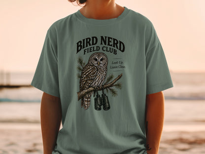 T-shirt with graphic of owl on branch with binoculars and text "Bird Nerd Field Club".