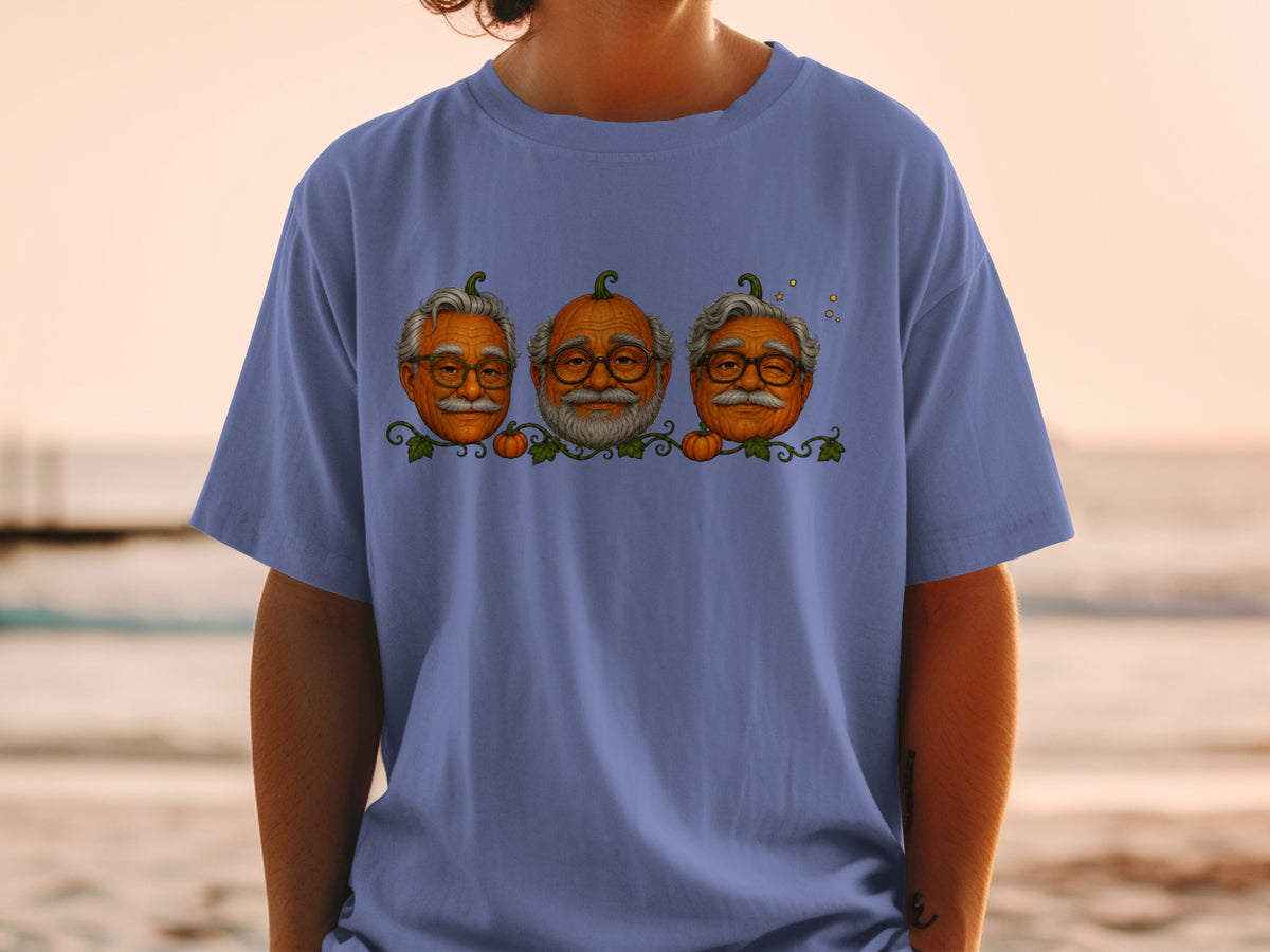 Three pumpkins with elderly faces and glasses on a purple t-shirt.