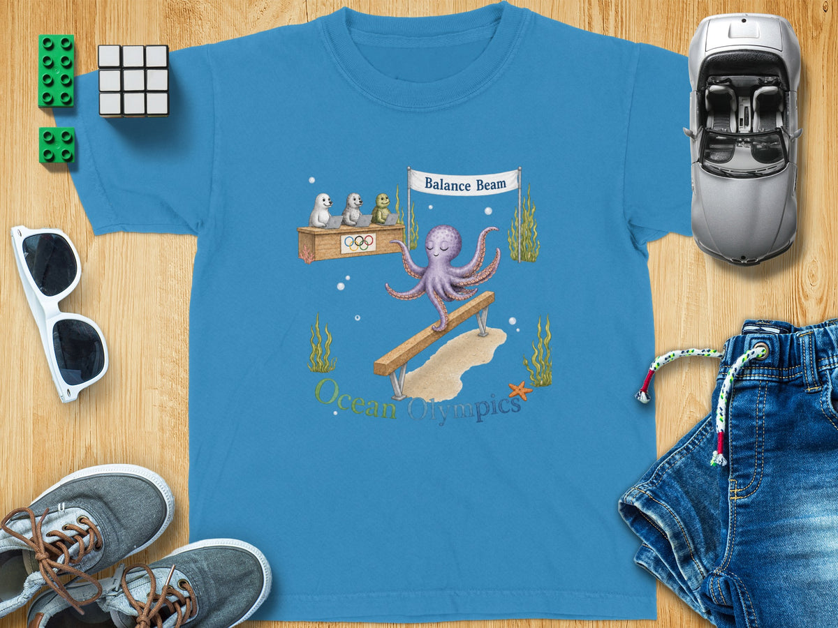 Blue t-shirt with octopus on balance beam and "Ocean Olympics" text.
