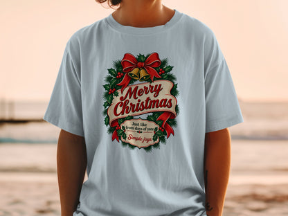 Light blue t-shirt with "Merry Christmas" text, holly, bells, and bow graphic.