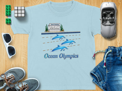 Light blue t-shirt with dolphins swimming and "Ocean Olympics" text.