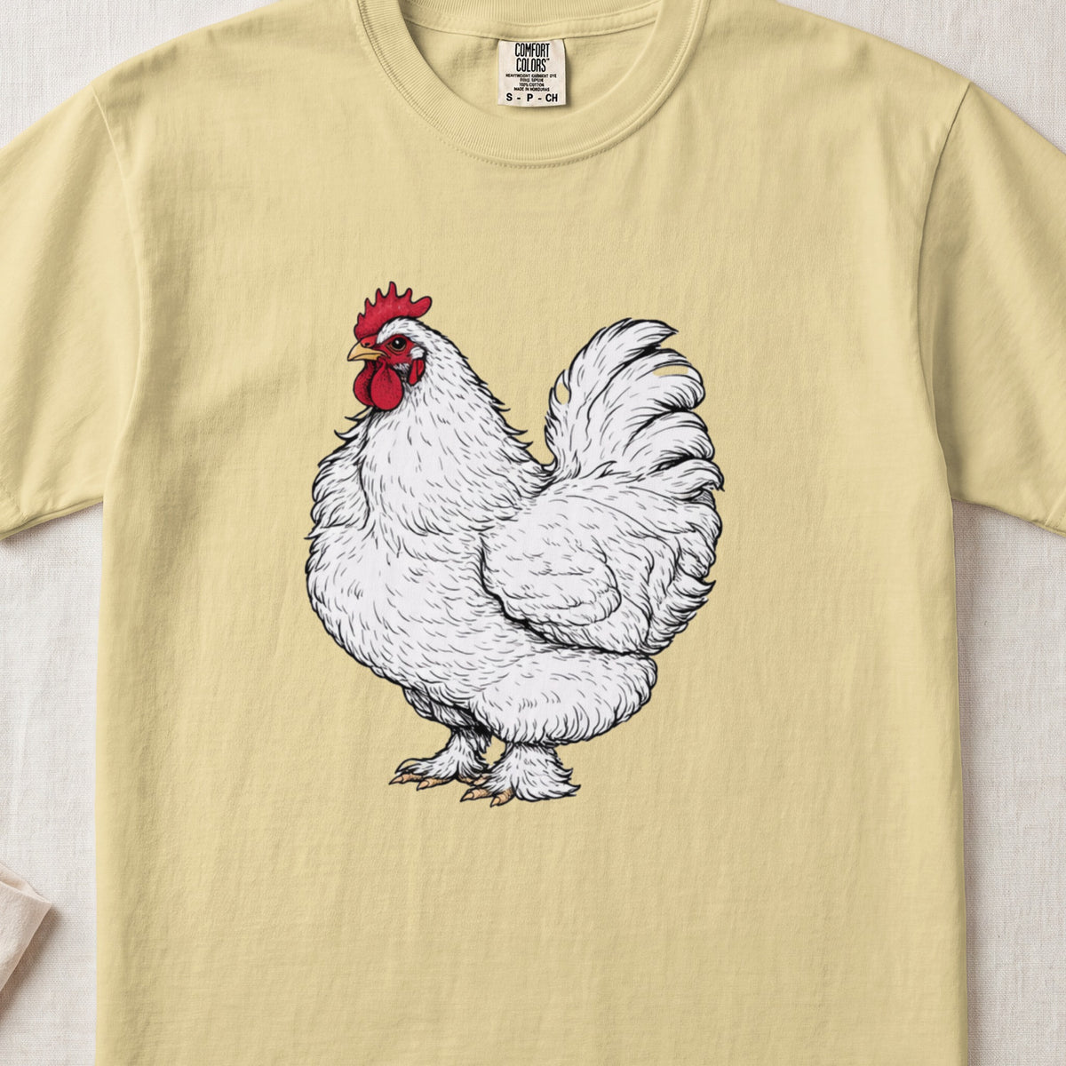 Pale yellow t-shirt featuring a detailed black and white illustration of a white rooster with a red comb.