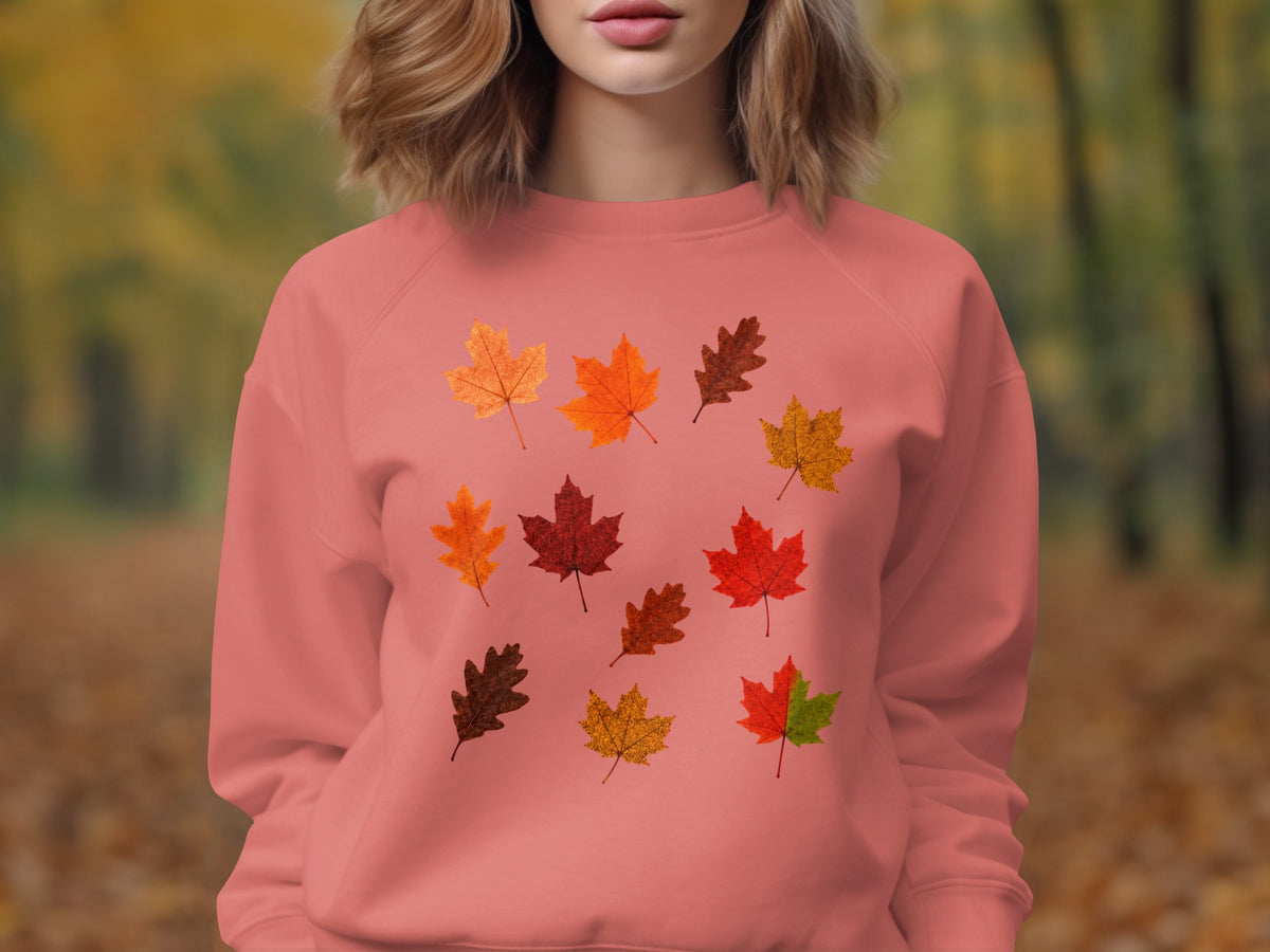 Pink sweatshirt with scattered autumn leaf graphics on front.