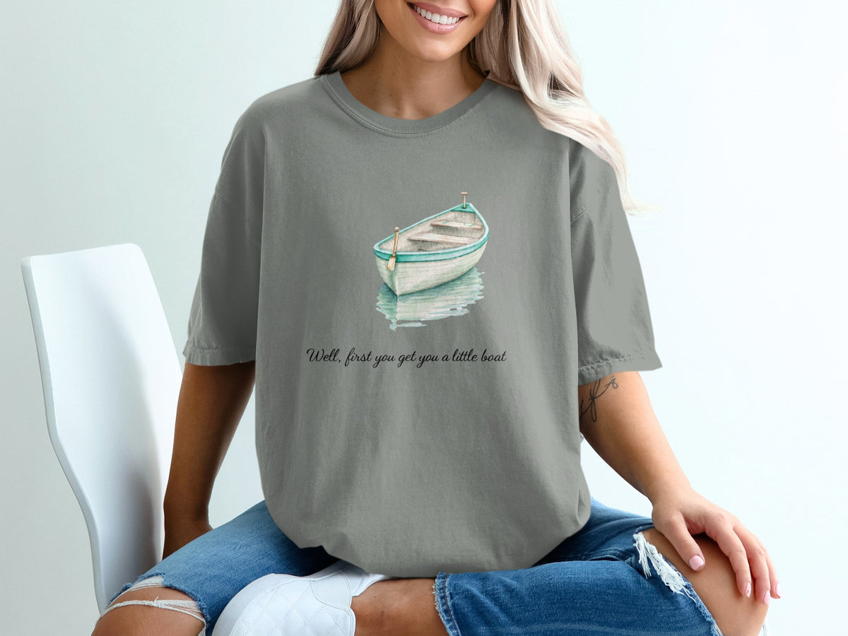 Grey t-shirt with watercolor boat and text "Well, first you get you a little boat".