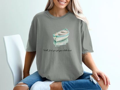 Grey t-shirt with watercolor boat and text "Well, first you get you a little boat".