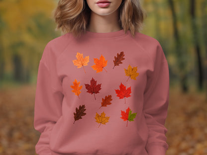 Pink sweatshirt with scattered autumnal leaf print on front.