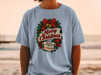 Light blue t-shirt with Merry Christmas design featuring holly, bells, and ribbon.