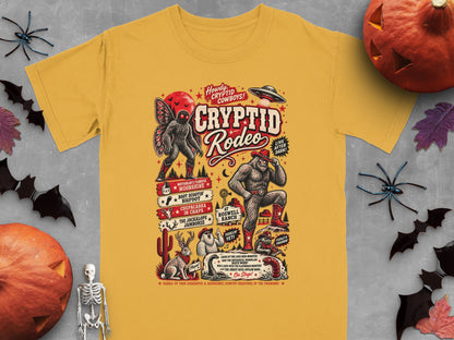 Yellow t-shirt with "Cryptid Rodeo" graphic featuring Bigfoot, Mothman, Chupacabra, Yeti, Jackalope, and UFO.