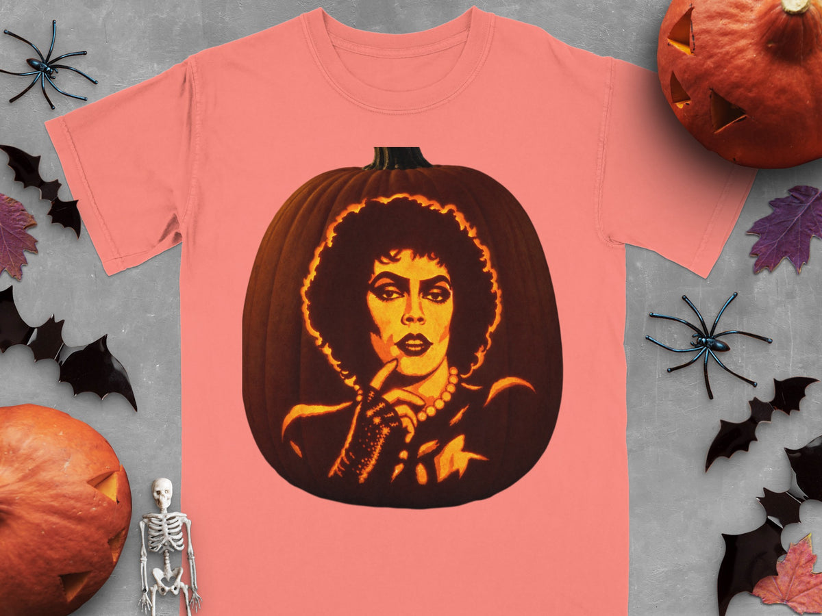Coral-pink t-shirt featuring a lit jack-o-lantern carved with a portrait of Frank-N-Furter from Rocky Horror.