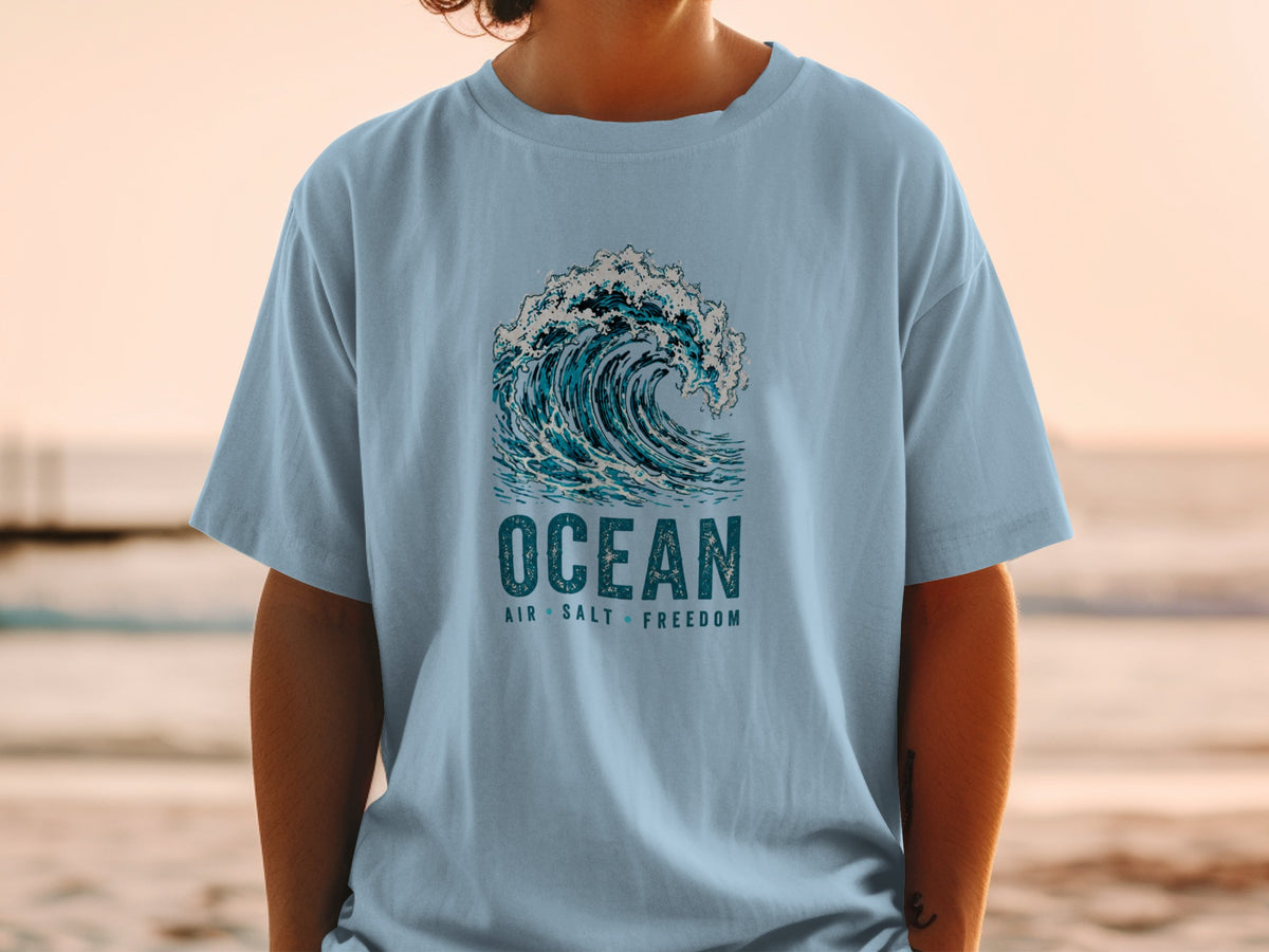 Light blue t-shirt with "OCEAN AIR SALT FREEDOM" text and wave graphic.