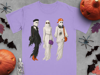 Three ghosts styled as fashion figures in Halloween-themed outfits on a purple shirt.