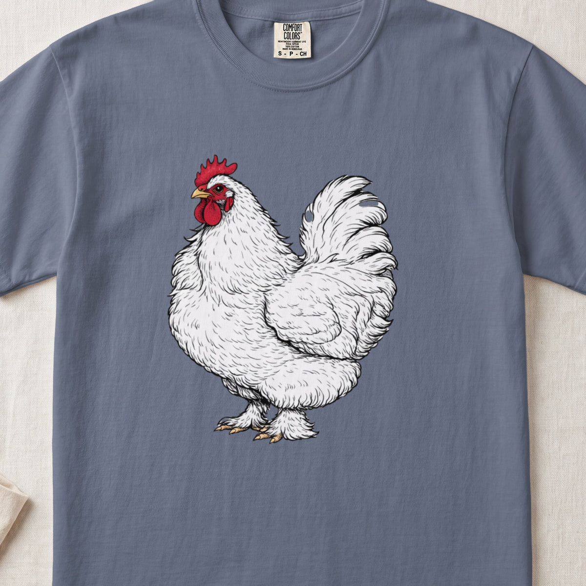 A blue crewneck t-shirt featuring a detailed illustration of a white rooster centered on the chest.