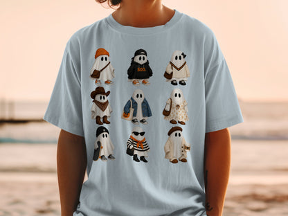Nine cartoon ghosts dressed in various Halloween-themed outfits on a light blue t-shirt.