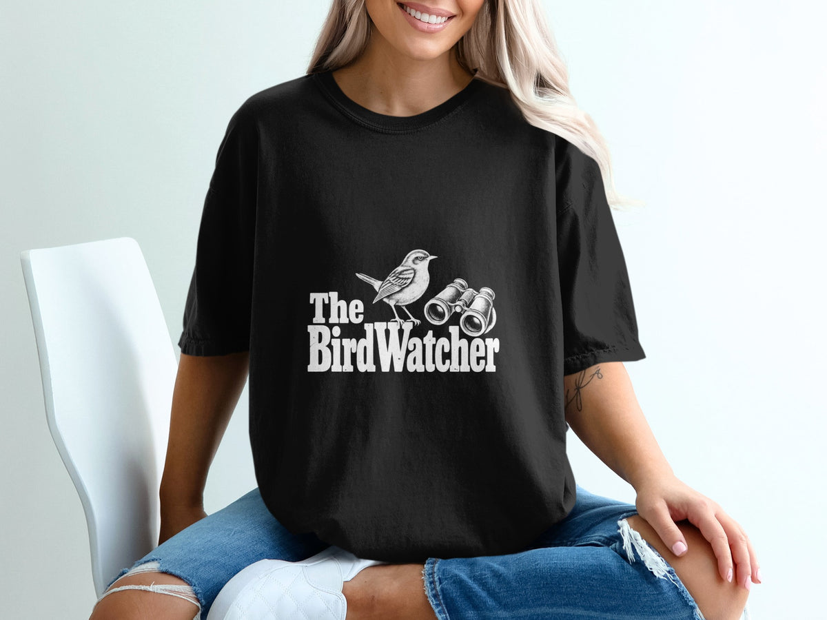 Black t-shirt with white text "The BirdWatcher" featuring a bird and binoculars illustration.