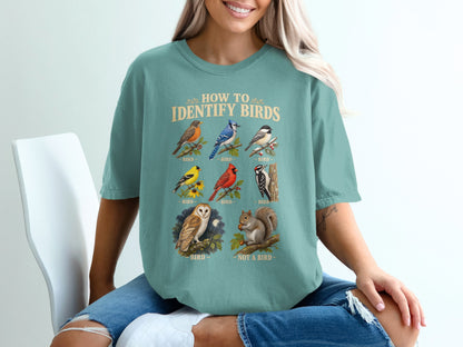 Teal t-shirt with "How to Identify Birds" text and illustrations of birds and a squirrel.