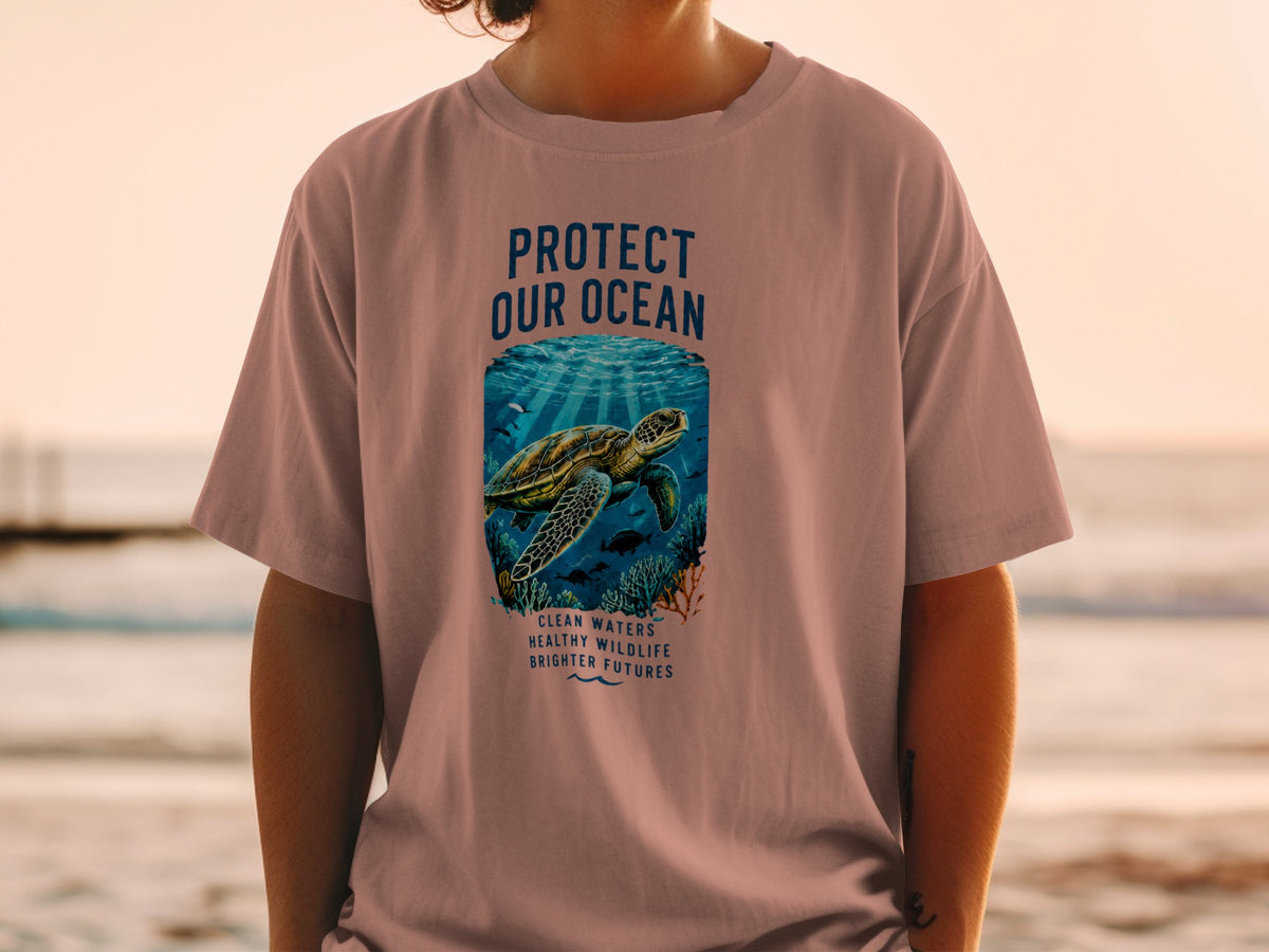 "Protect our ocean" graphic with turtle, fish, coral, and text on a pink t-shirt.