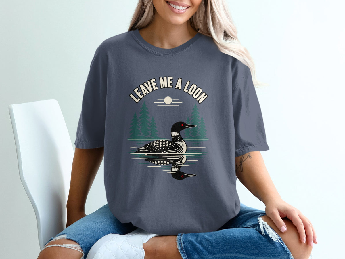 T-shirt graphic with a loon on water and text "Leave Me A Loon".
