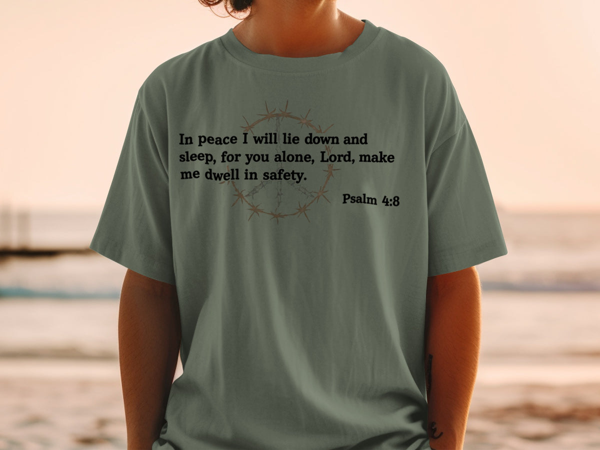 Green t-shirt with barbed wire peace symbol and Bible verse.