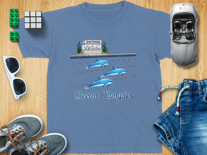 Blue t-shirt with a graphic of dolphins swimming and "Ocean Olympics" text.