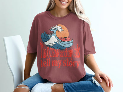T-shirt with a wave graphic and text "The Ocean and my tats tell my story".