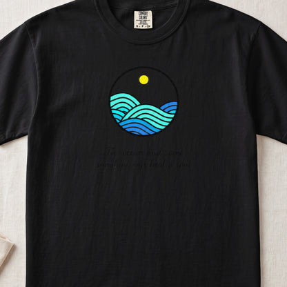 Black t-shirt featuring a circular graphic of blue ocean waves under a yellow sun and text.