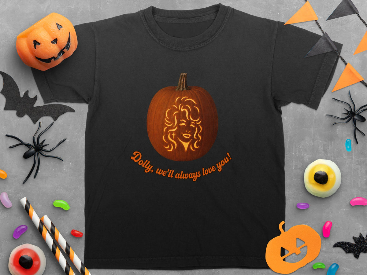 Black t-shirt with a carved pumpkin featuring Dolly Parton and text "Dolly, we'll always love you!".