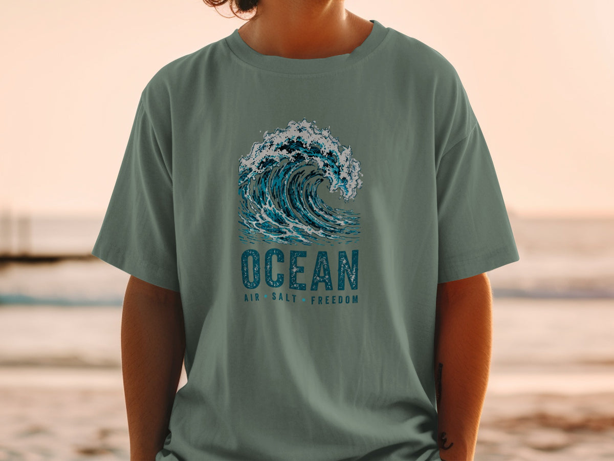 T-shirt with a graphic of a crashing wave and text "OCEAN AIR SALT FREEDOM".