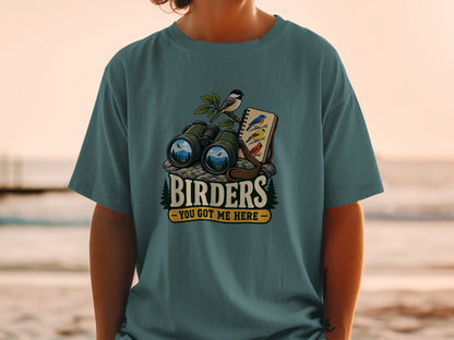 T-shirt with graphic of binoculars, birds, and text "Birders - You Got Me Here".