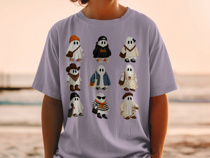 Nine cartoon ghosts in various outfits, some with Halloween themes, are printed on a purple t-shirt.
