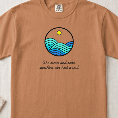 Brown t-shirt featuring a circular ocean graphic with a yellow sun and the text "The ocean and some sunshine can heal a soul."