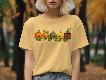 Yellow t-shirt with a line of five smiling jack-o'-lanterns and vines.