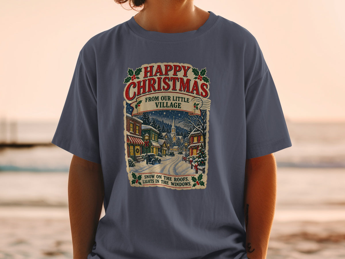 T-shirt with "Happy Christmas From Our Little Village" text and snowy village scene.