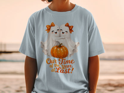 Two ghosts embrace a pumpkin with text "Our Time of the Year, at Last!".