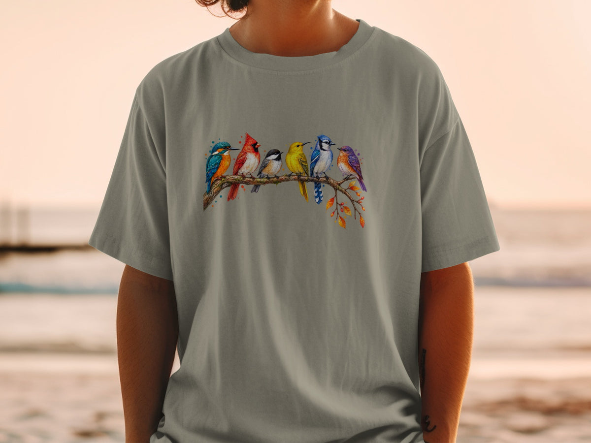 T-shirt with watercolor art of six colorful birds perched on a branch.