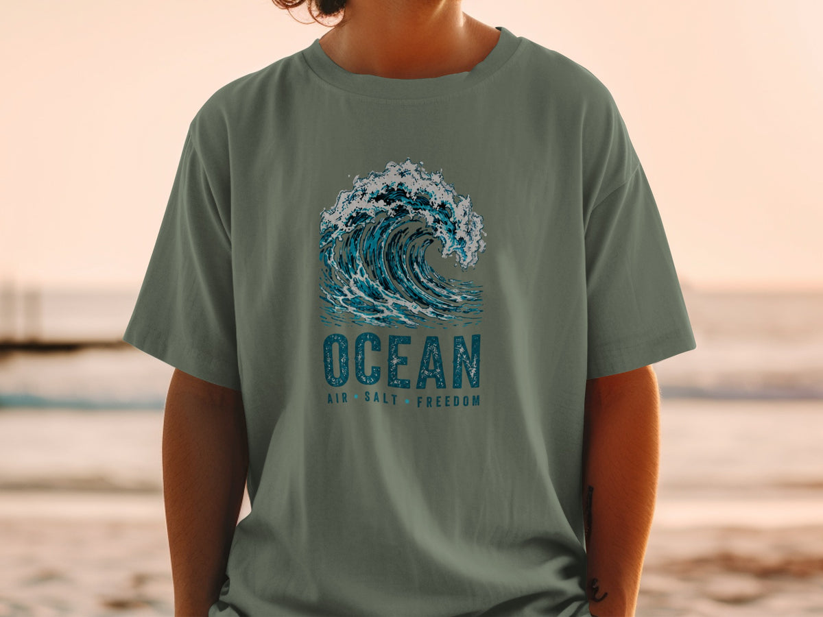T-shirt with a crashing wave graphic and text "OCEAN AIR SALT FREEDOM".